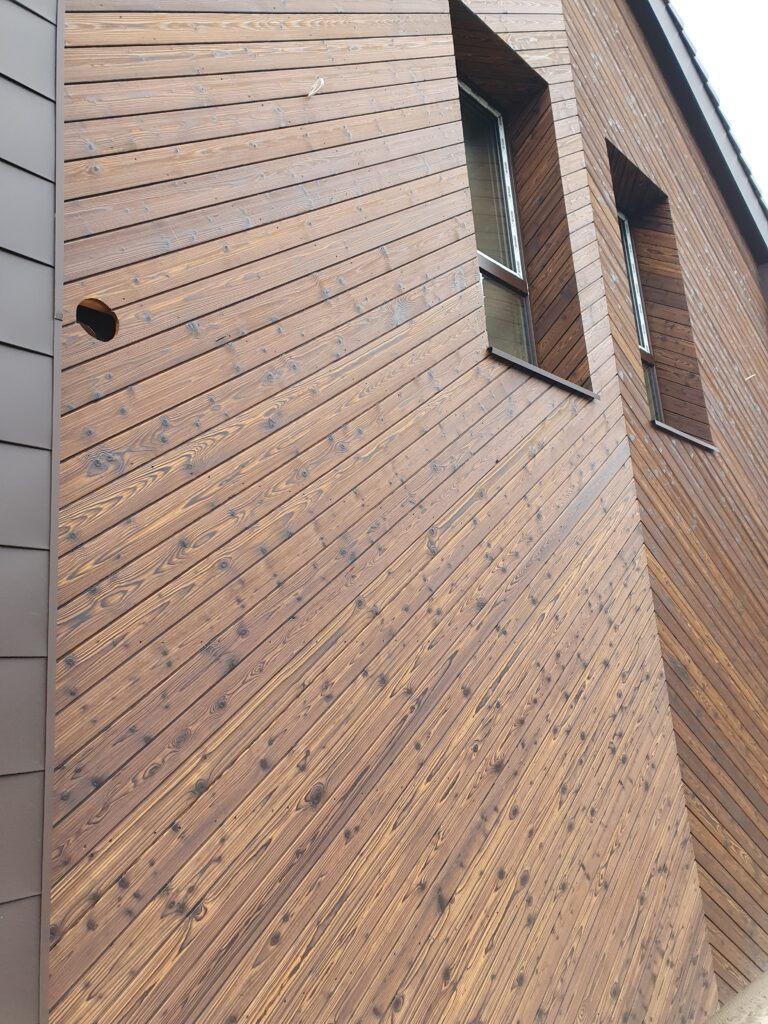 Merevaigu tooni põletatud puidust eramaja fassaad