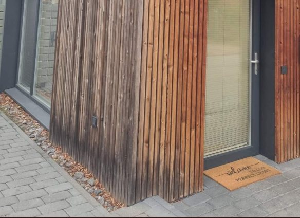 Vertikaalne termopuitfassaad hoone nurgal, sissepääsu juures